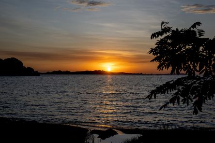 Die Sonne geht über einem See unter