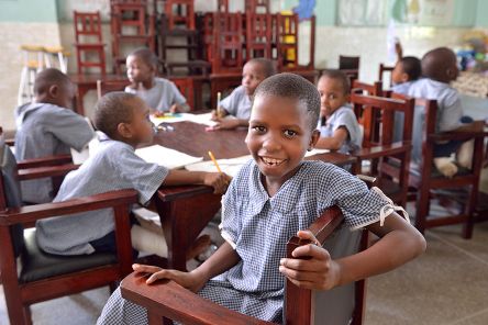 Afrikanische Kinder in Schuluniform im Klassenzimmer.