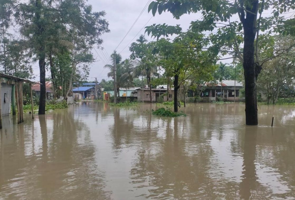 Häuser und Bäume in einem überschwemmten Gebiet stehen teil unter Wasser.